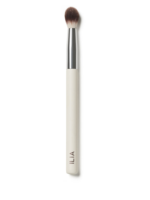 An ILIA Blending Brush with a white handle that is complemented by an oversized, fluffy brush.