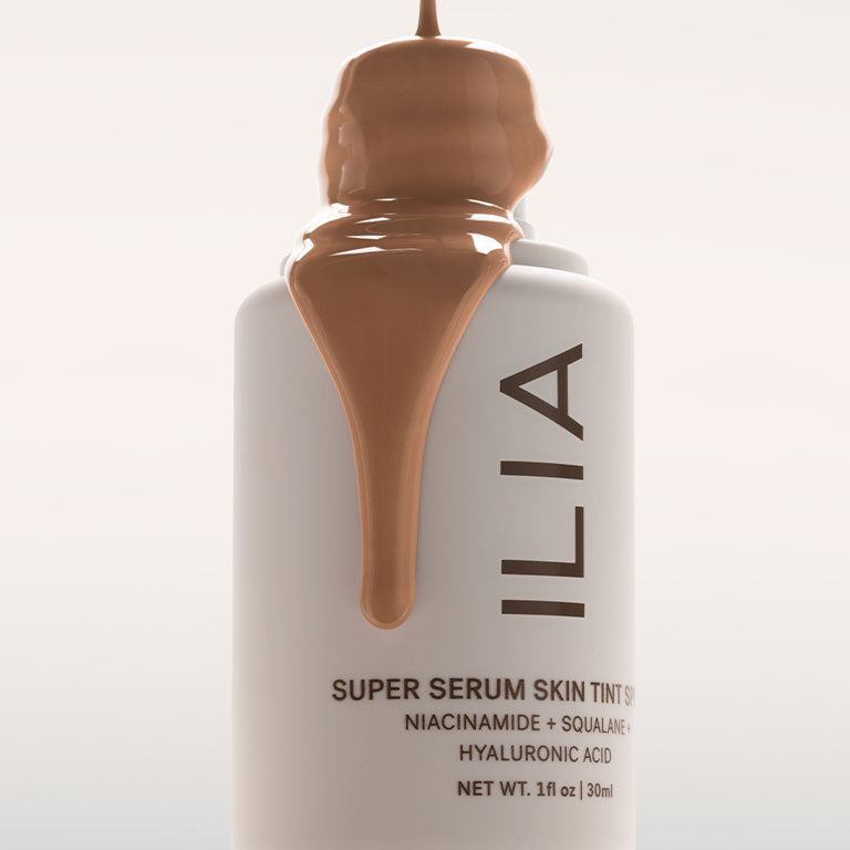 ILIA's Super Serum Skin Tint SPF 40 dripping down the side of the bottle in a cinematic way.