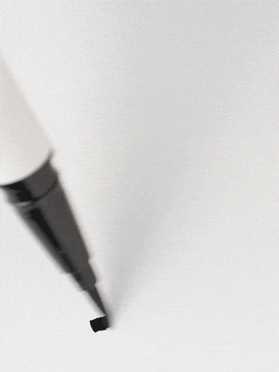 GIF of a white ILIA Liquid Eyeliner with a fine black felt tip drawing  on a surface.