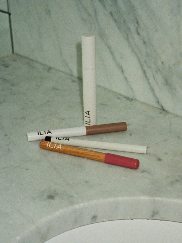 An array of ILIA products on a marble surface