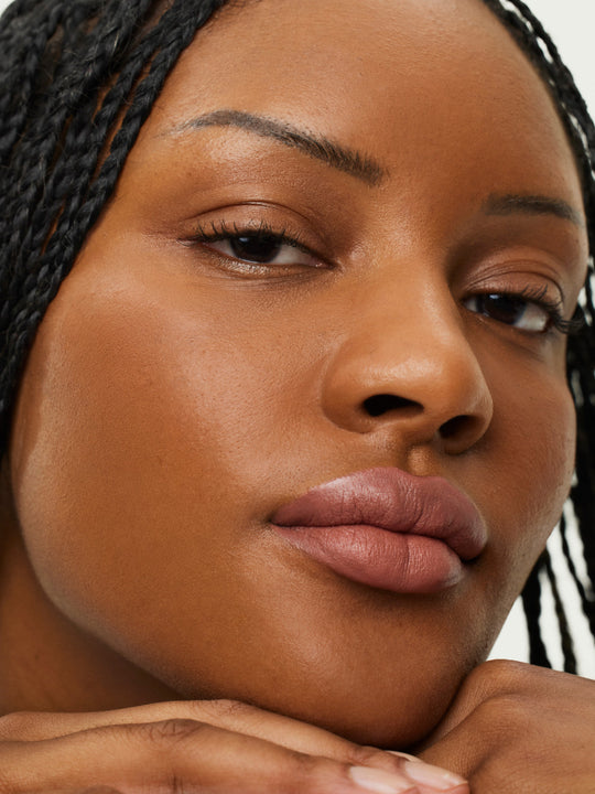 ILIA lip liner pencil with a natural wood finish, featuring a muted pink tip and matching cap placed beside it.